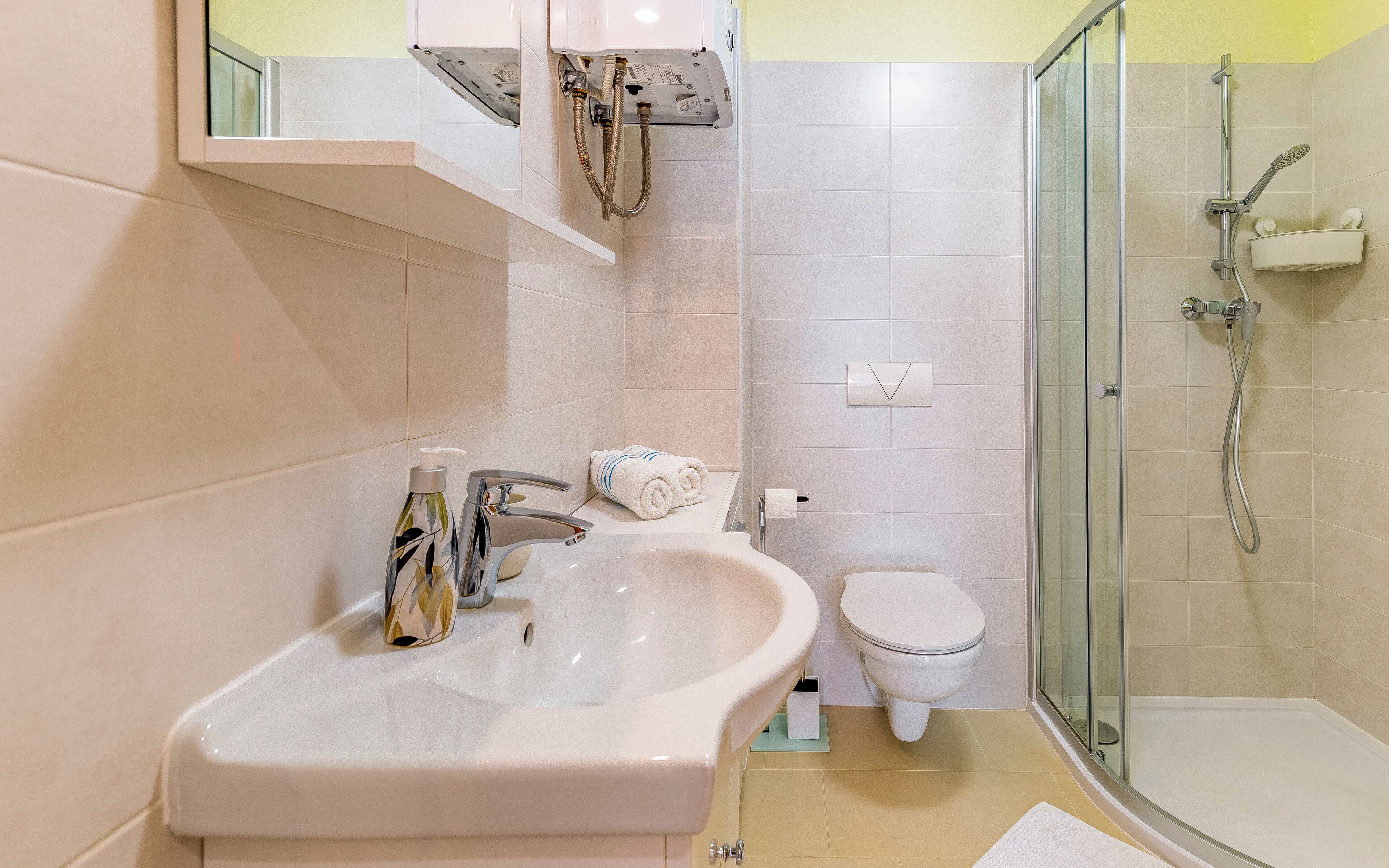 A bathroom with a sink, toilet, and glass-enclosed shower.
