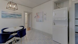 Una cocina moderna con horno empotrado, una zona de comedor con una mesa redonda y sillas azules, y un suelo con diseño.