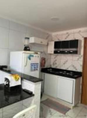 A kitchen with white cabinets, a black countertop, and a stove.