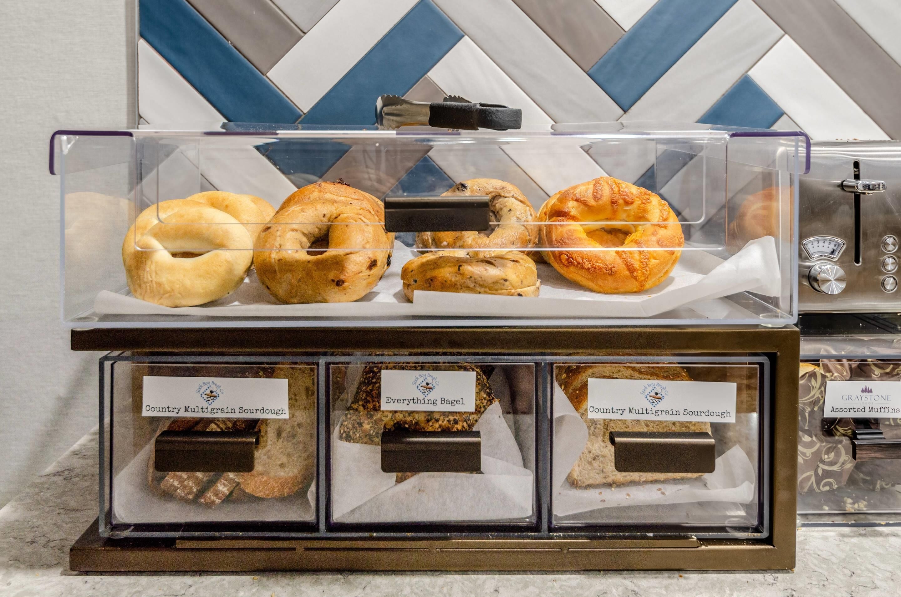 Una vitrina de panadería con bagels y pan de masa madre.