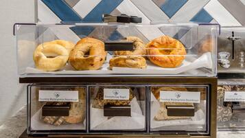 Una vitrina de panadería con bagels y pan de masa madre.