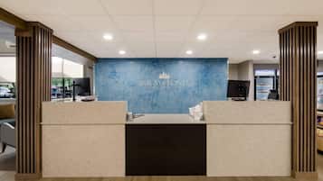 A reception desk with a blue marble wall and the name "GRAYSTONE LODGE" in the center.