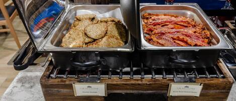 A buffet with two hot food stations, one labeled 'County Sausage' and the other 'Apple Wood Smoked Bacon'.