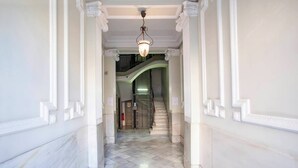 A hallway with marble flooring, white walls, and a staircase leading to an upper level. - P2PAR1002- Super Bright & New 2B Apt in the center (Barcelona)