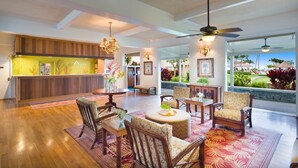 A spacious lobby with a reception desk, seating area, and a view of the outdoor garden.