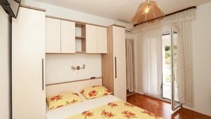 A bedroom with a bed, a wardrobe, a ceiling light, and a window with curtains. - Apartments Pezo - Superior Two Bedroom Apartment with Balcony (Baška Voda)
