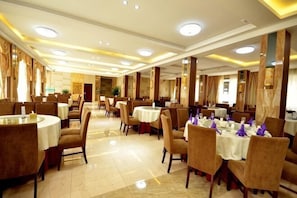 A spacious dining area with round tables and chairs, a chandelier, and a marble floor. - Xiannv Mountain Wanghao Hotel (Chongqing)