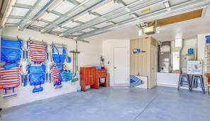 A garage with a concrete floor, a wooden cabinet, and a door leading to another room. - SALT Pool, Golf, Master Suite, Near Sandy Beaches (Rotonda West)