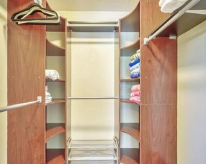 A walk-in closet with wooden doors, metal rods, and shelves for hanging clothes. - SALT Pool, Golf, Master Suite, Near Sandy Beaches (Rotonda West)