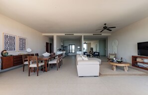 A spacious living room with a dining area, a sofa, a TV, and a ceiling fan.