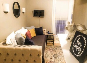 Relax in comfort with a plush bed, tufted headboard, and flat-screen TV.