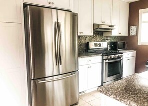 Enjoy cooking in this well-equipped kitchen with a refrigerator, oven, microwave, and toaster oven.
