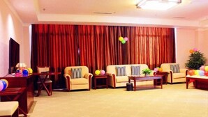 Una sala de estar con dos sofás, una mesa de centro y un televisor. Hay globos y una planta pequeña sobre la mesa.