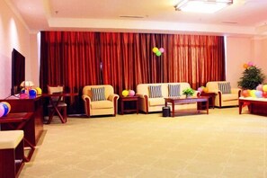 Un salon avec deux canapés, une table basse et un téléviseur. On peut y voir des ballons et une petite plante sur la table basse.