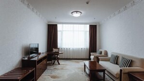 Una sala de estar moderna con sofá, televisión y zona de comedor.