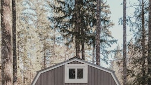 A small wooden cabin with a porch, a door, and windows. - Clay Baby- luxury shed conversion on the river + Epic Sauna + Cold Plunge (Sultan)