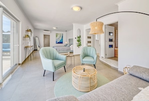 A modern living room with a sofa, two armchairs, a coffee table, and a large window. - Villa Beleza - Elegant Villa on Penina Golf Course (Alvor)
