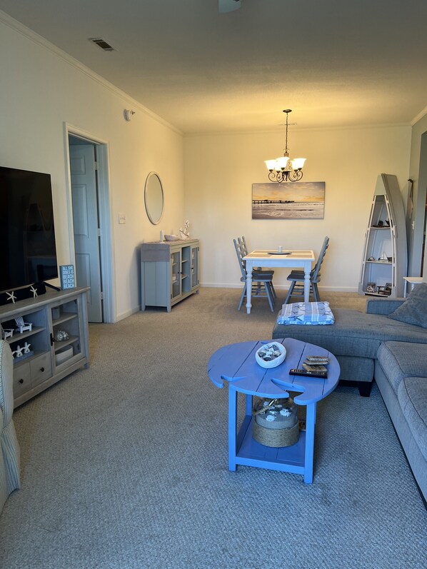 A living room with a TV, a dining table, and a sofa. - Relax in Lewes Condo near the beaches! (Lewes)