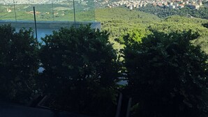 Une vue depuis un balcon donnant sur un paysage urbain côtier, avec un ciel dégagé.