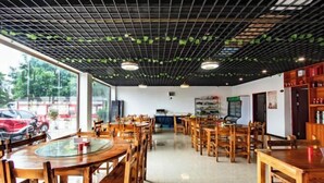 A restaurant with wooden tables and chairs, a grid-patterned ceiling, and large windows overlooking the street. - Hongxin Hotel (Jinggangshan City)