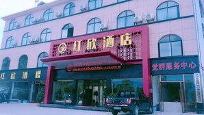 A hotel with a prominent red and yellow sign, large windows, and a black vehicle parked in front. - Hongxin Hotel (Jinggangshan City)