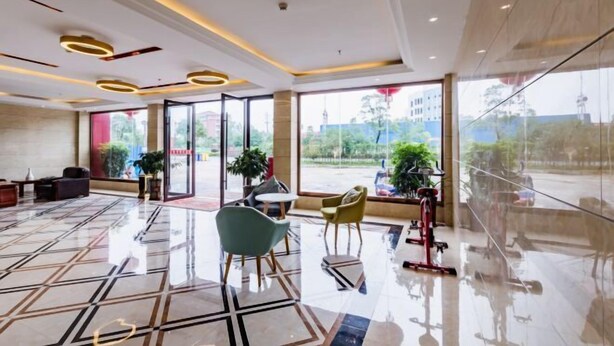 A modern lobby with a geometric floor pattern, contemporary furniture, and large windows offering a view of the outside. - Hongxin Hotel (Jinggangshan City)