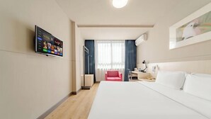 A hotel room with a bed, a desk, a chair, a TV mounted on the wall, and a window with curtains. - Jinjiang Inn (Shanghai International Tourist Resort Kangxin Highway) (Shanghai)