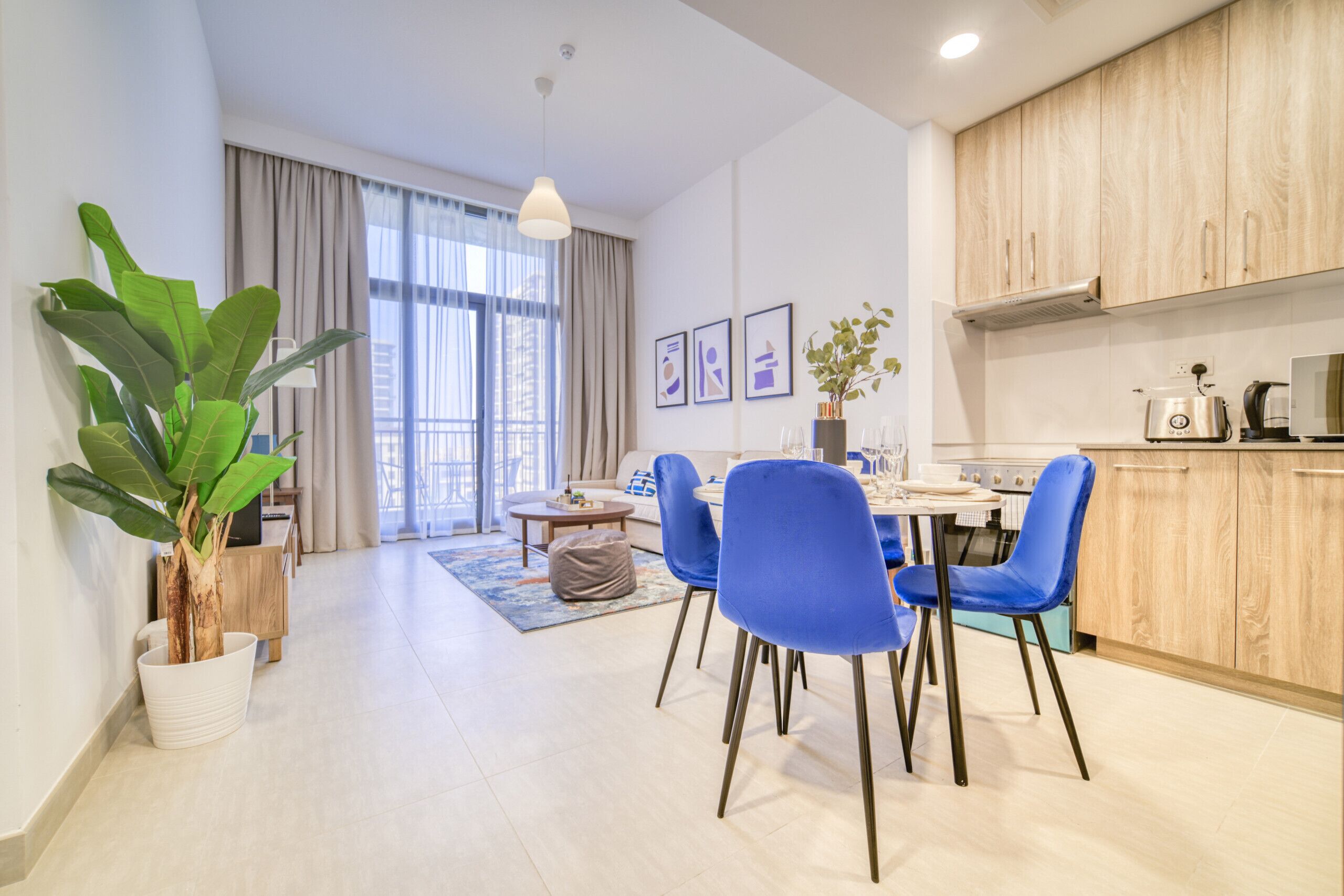 Un appartement moderne doté d’un coin repas, d’une cuisine et de grandes fenêtres.