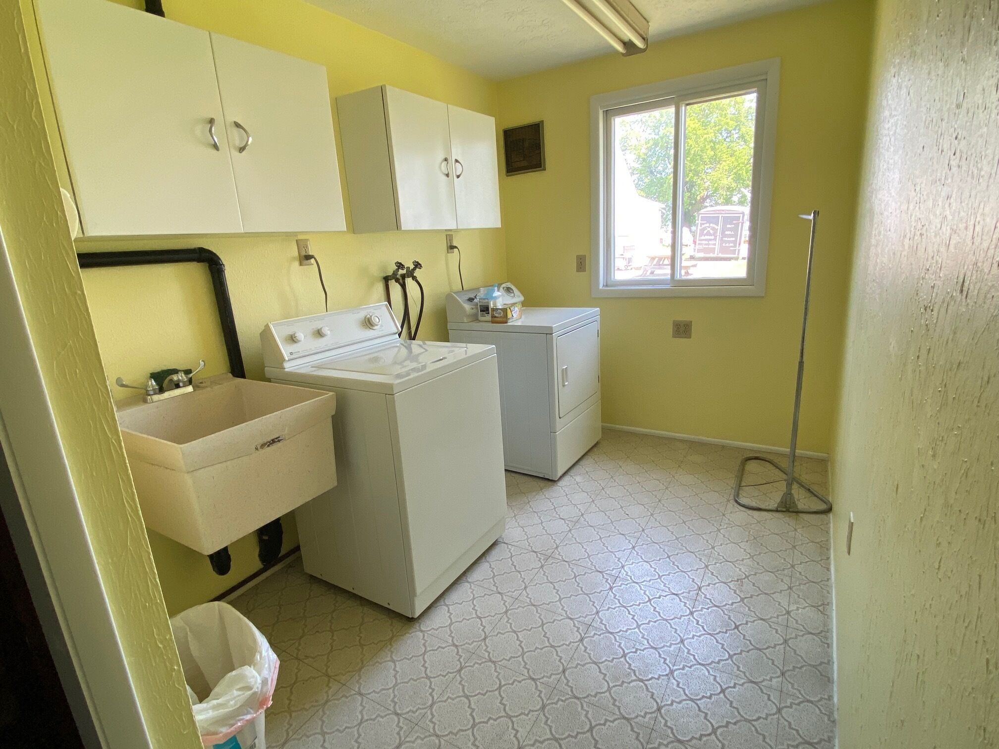 A laundry room with a washing machine, dryer, and a sink.