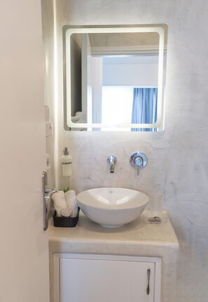 Ein Badezimmer mit Waschbecken, Spiegel und Handtuchhalter.