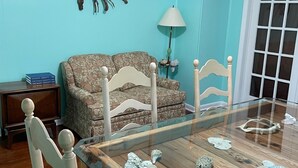 A dining area with a wooden table, chairs, and a sofa. - Seaside Retreat (Wachapreague)