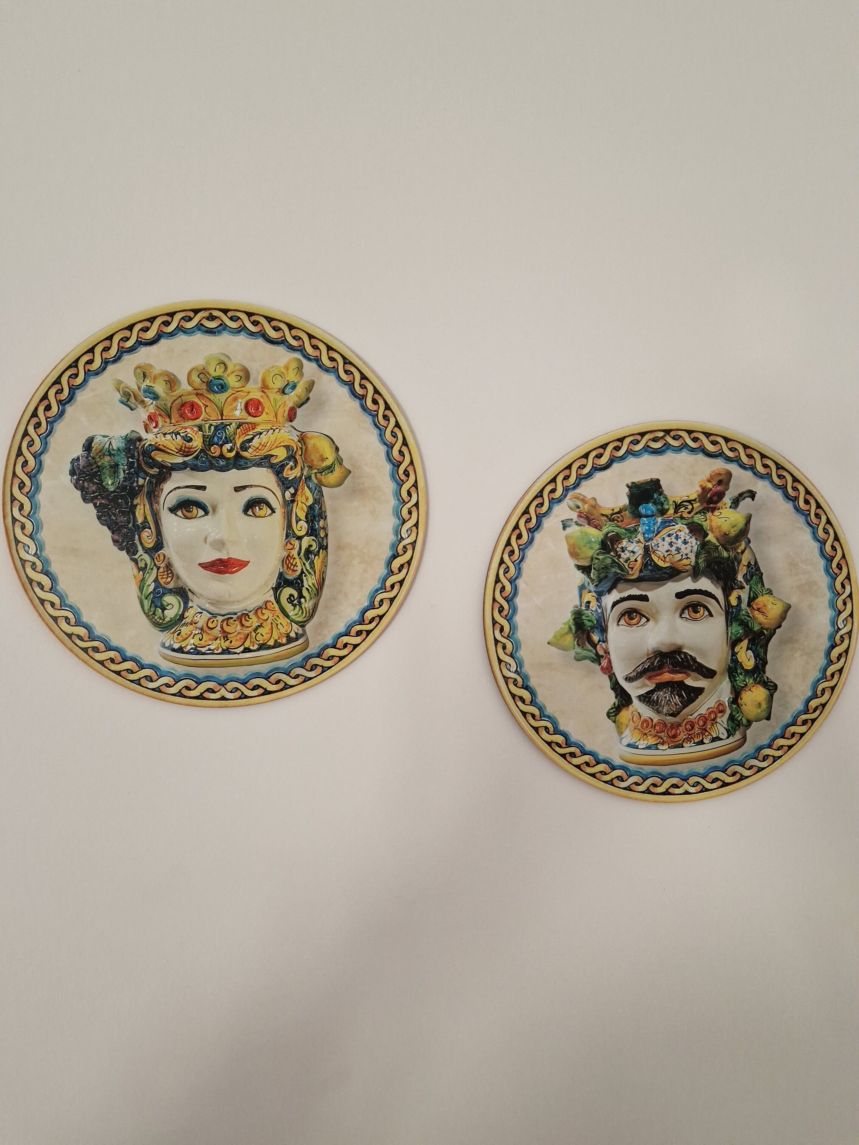 Due piatti in ceramica con decorazioni elaborate e un bordo ornamentale.