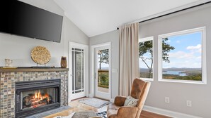 A modern living room with a fireplace, comfortable seating, and large windows offering scenic views. - Modern Mountain Oasis • 5BR with Million-Dollar Lake Views • EV• Hot Tub • PetOK (Blue Ridge)