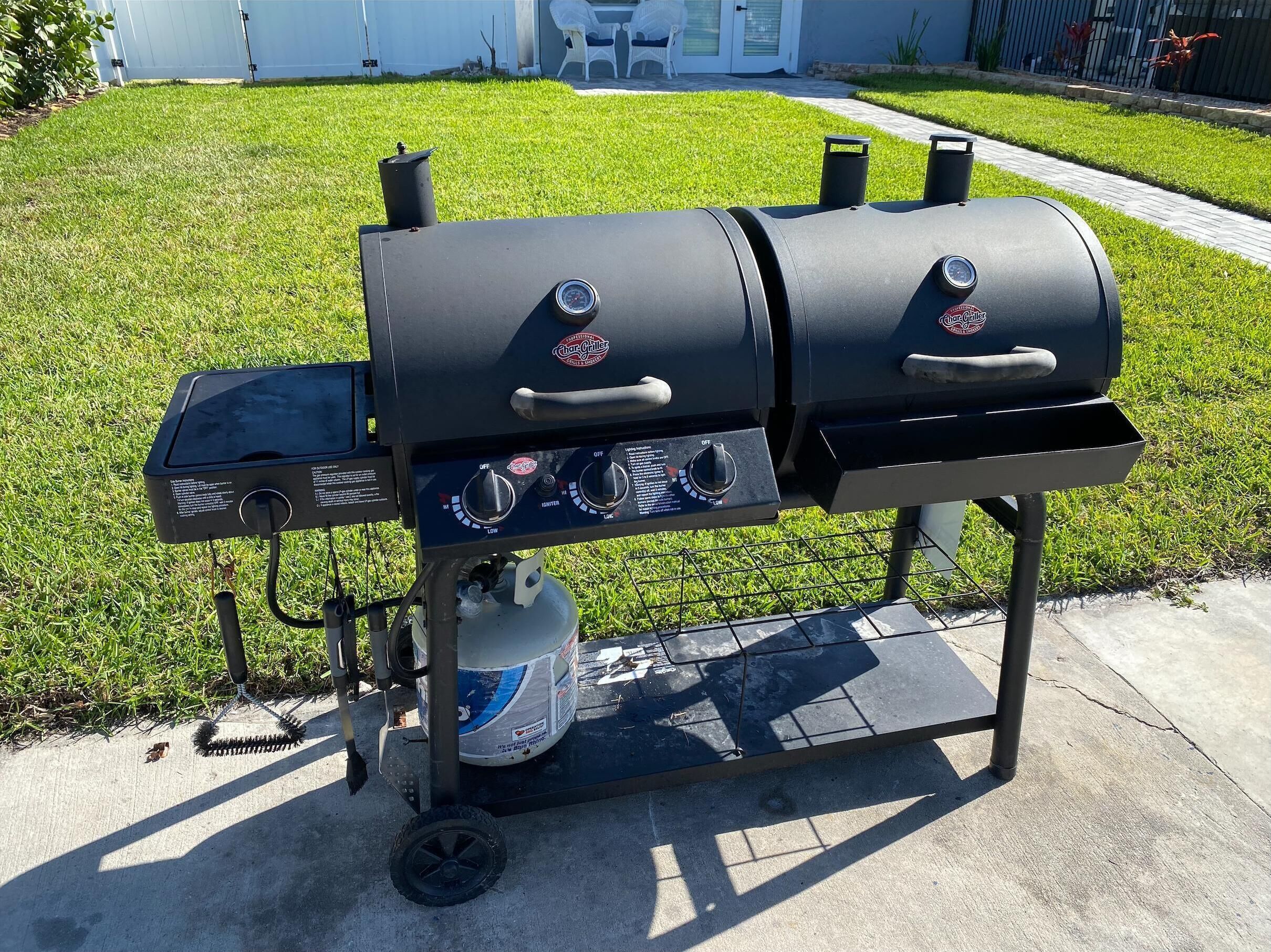 Una parrilla Char-Griller de dos quemadores, con pantalla digital, tanque de combustible y perillas de control.