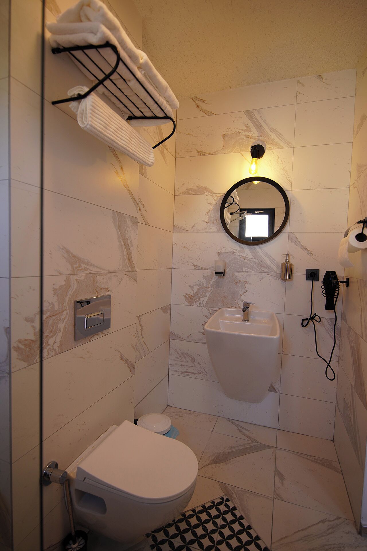 Ein modernes Badezimmer mit Toilette, Waschbecken und Handtuchhalter.