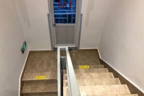 A staircase with a handrail and yellow signs on the steps. - Abin Inn (Shanghai)