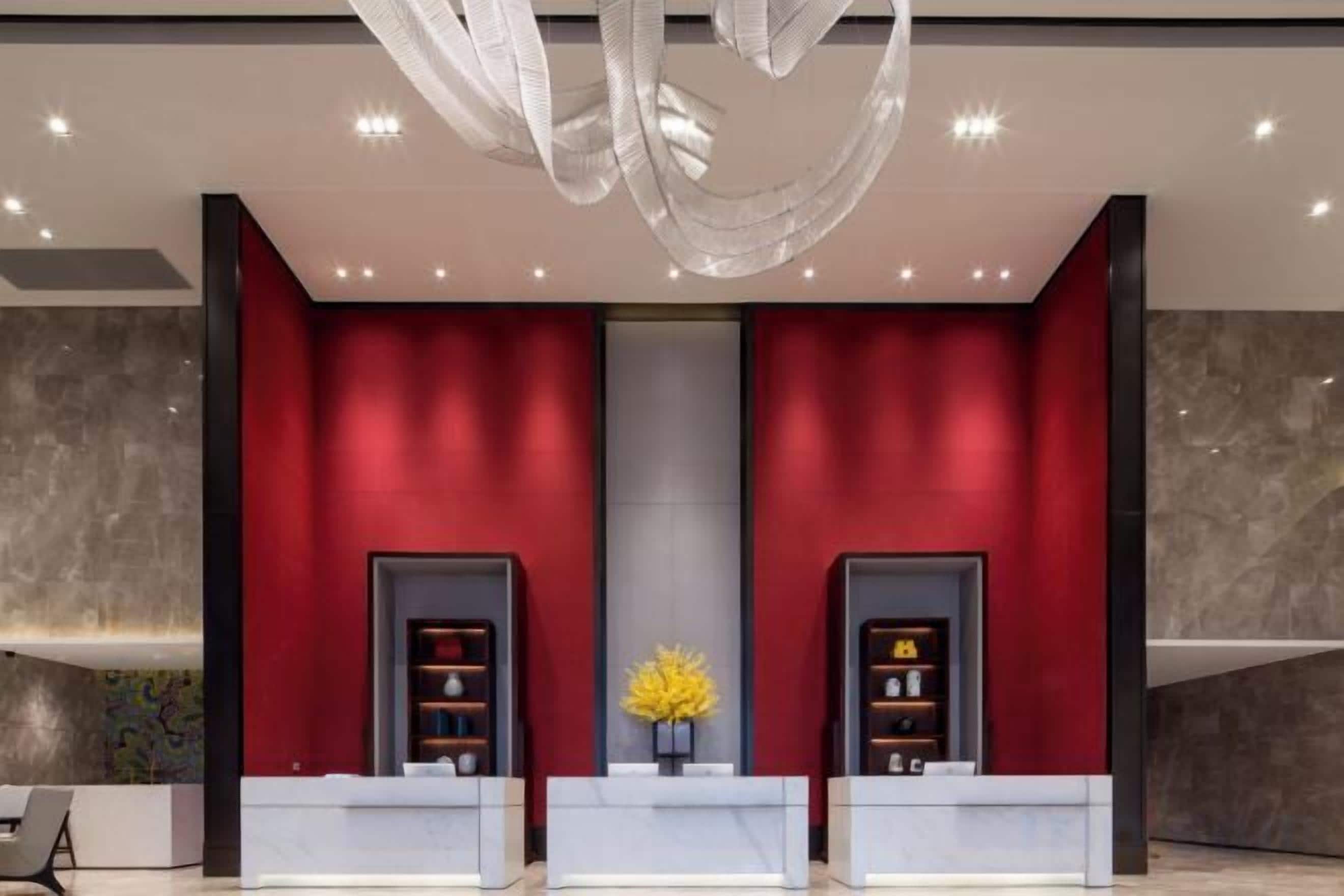 A reception area with two counters, a chandelier, and a central decorative element.