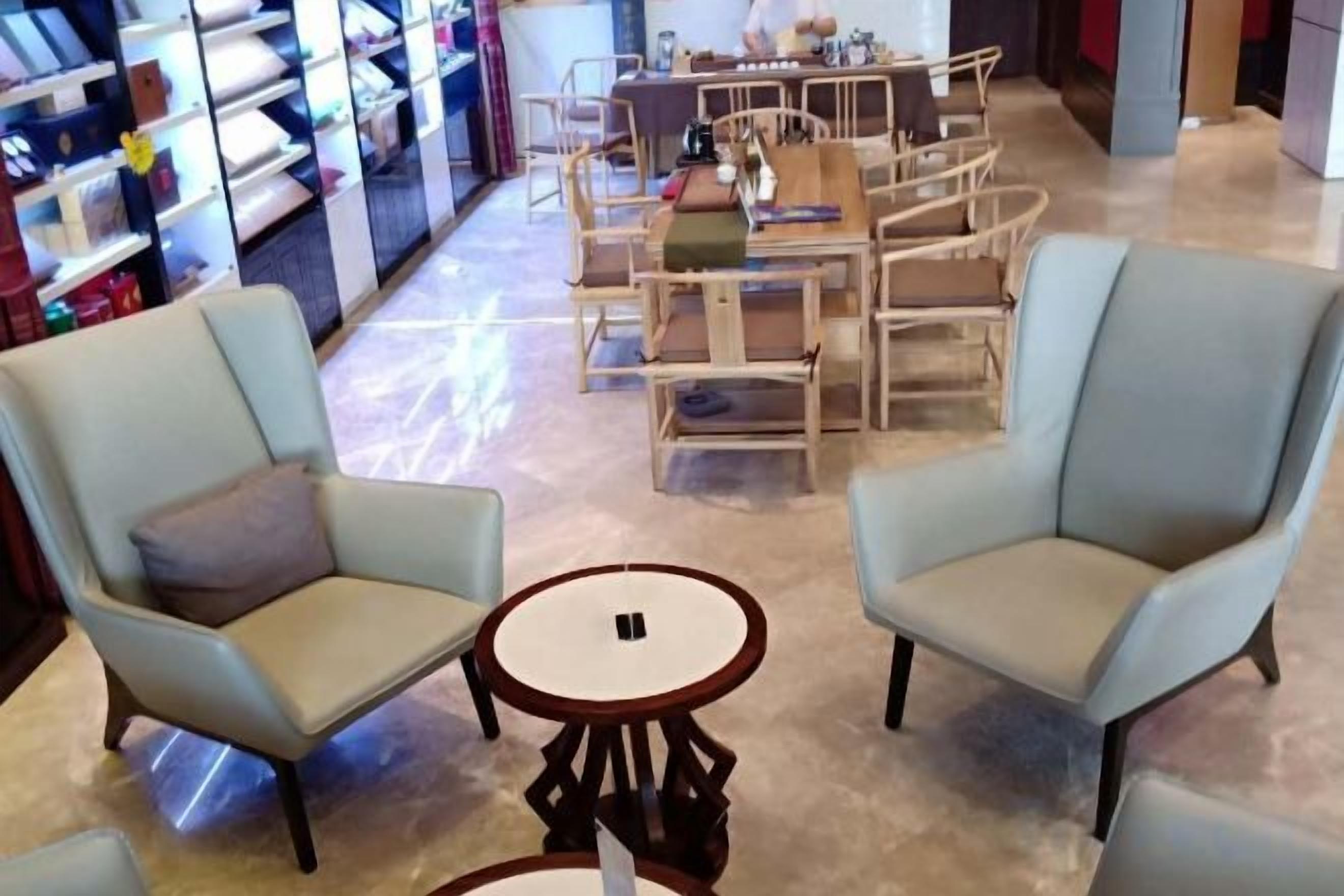 A seating area with two light blue armchairs and a small round table.