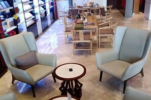 Una zona de estar con dos sillones azul claro y una mesita redonda.