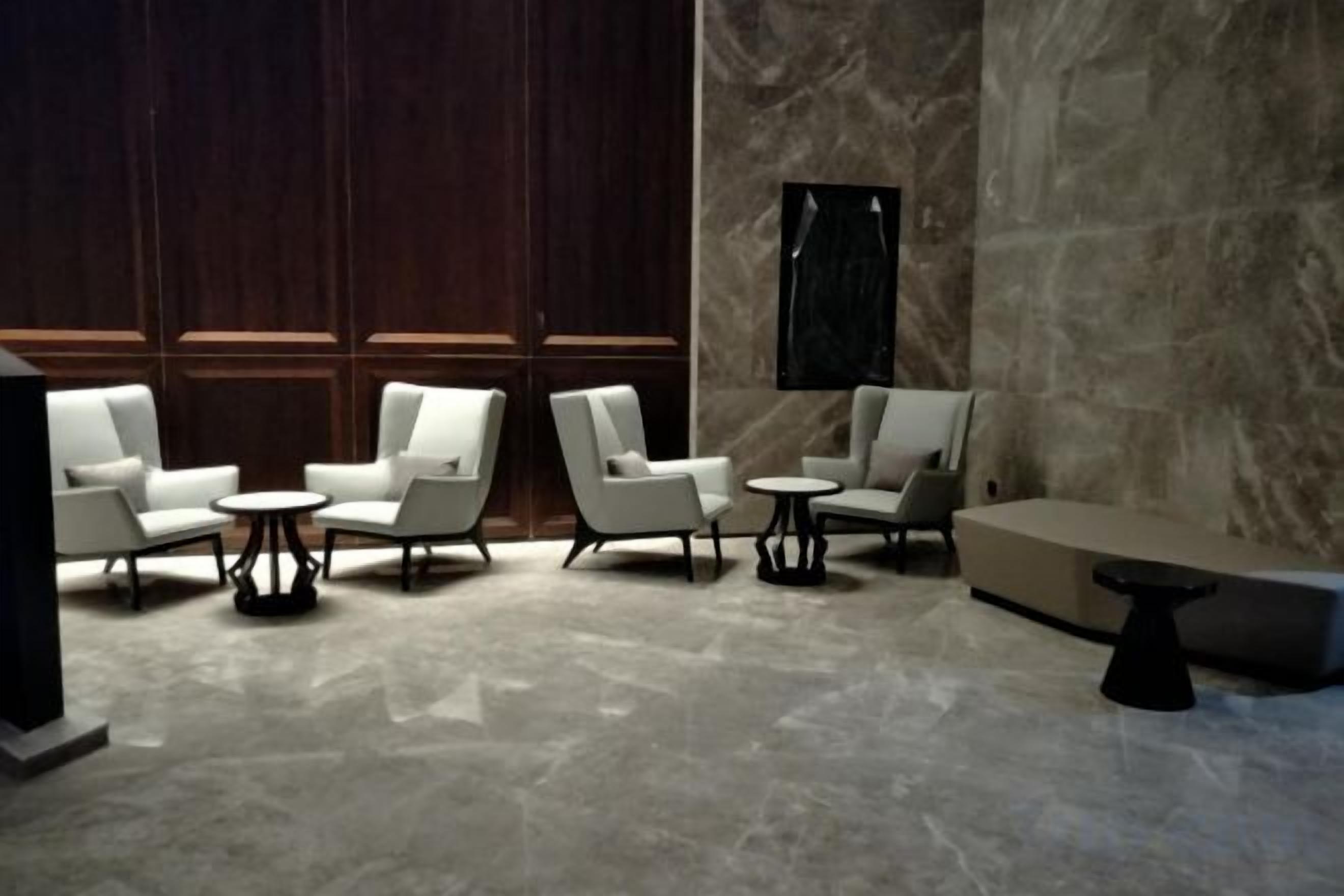 A modern lounge area with seating arrangements and a marble floor.