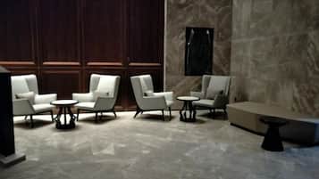 A modern lounge area with seating arrangements and a marble floor.