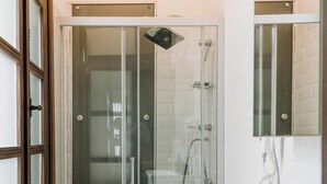A bathroom with a glass-enclosed shower, a toilet, a sink, and a mirror. - Nill's Stone House Otel (Cesme)