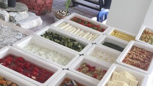 A buffet with various food items in white trays, including rice, vegetables, and meats. - Lutfiye Sigacik (Seferihisar)