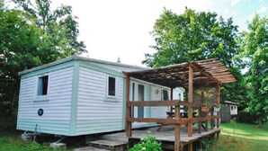 A mobile home with a wooden deck and a covered porch. - Mobile home in Xaintrie (SAINT-GENIEZ-Ô-MERLE)