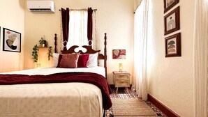 Una camera d'albergo con un letto grande, un comodino con una lampada e un piccolo tappeto.
