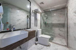 A modern bathroom with a large mirror, a white sink, a toilet, and a glass-enclosed shower area. - Baba Boutique Hotel (Xiamen)