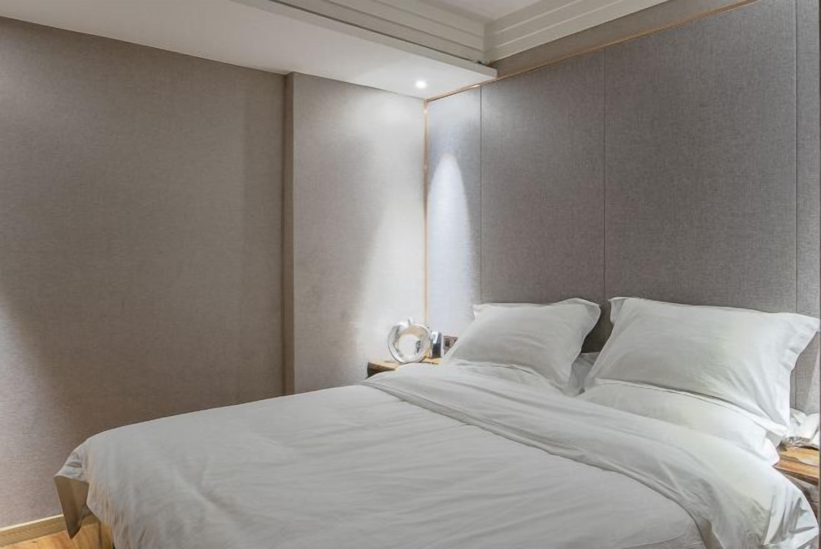 Un dormitorio con cama, mesita de noche y espejo.