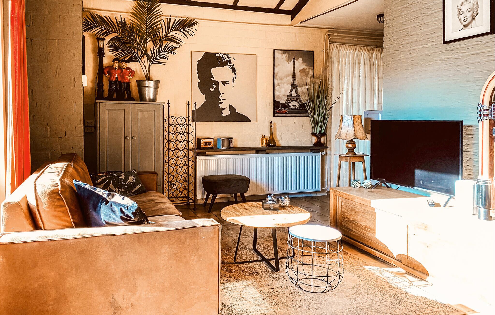 A living room with a sofa, a coffee table, a TV, and a radiator.
