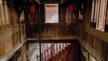 A multi-level wooden structure with a staircase, wooden railings, and traditional windows.