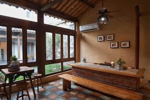A patio area with a brick counter, wooden furniture, and large windows. - Yanshe Inn (Huangshan City)